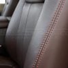 Contrasting Tangerine double-stitching on coffee leather
