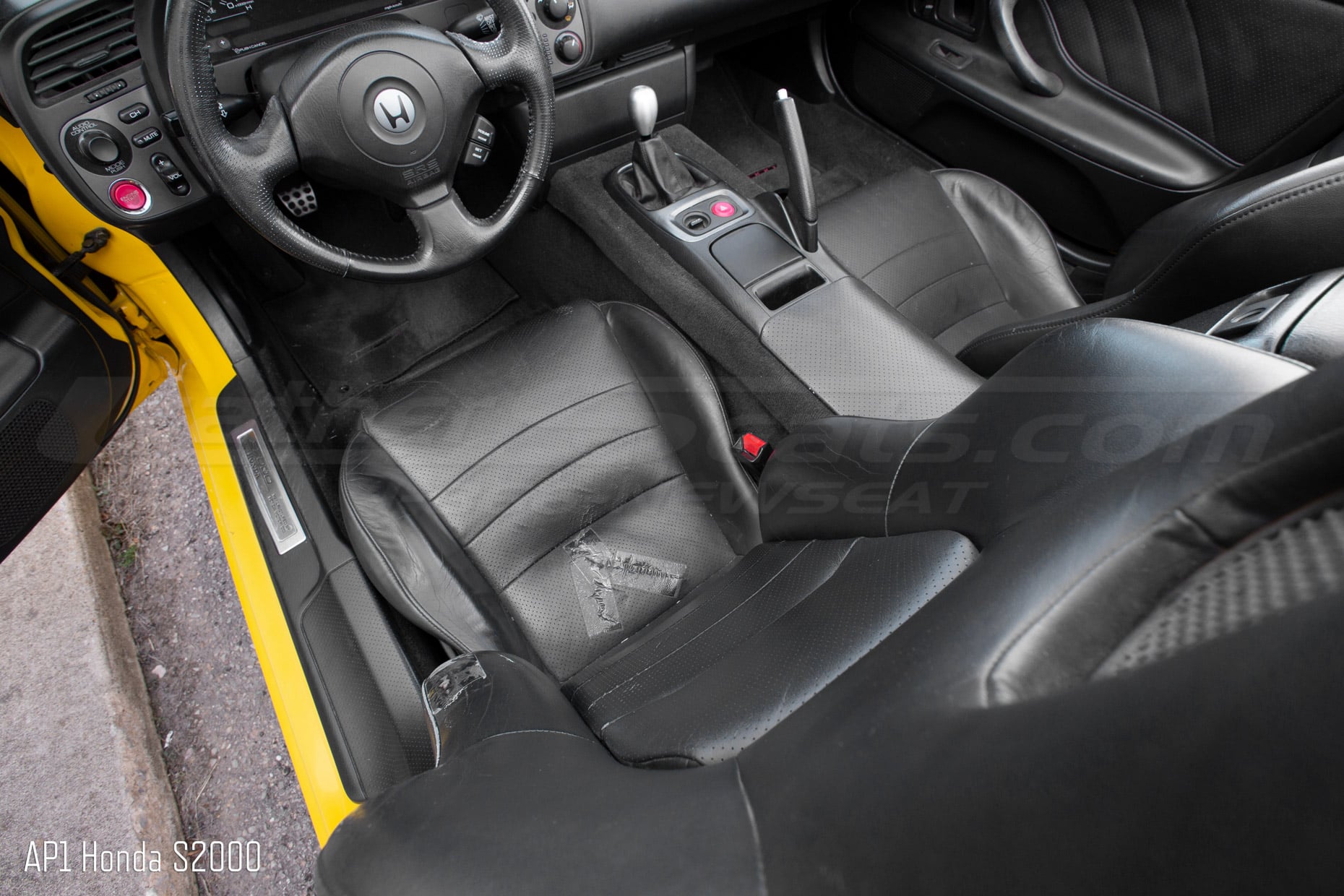 Top down view of hondsa s2000 roadster with torn seat cushion upholstery