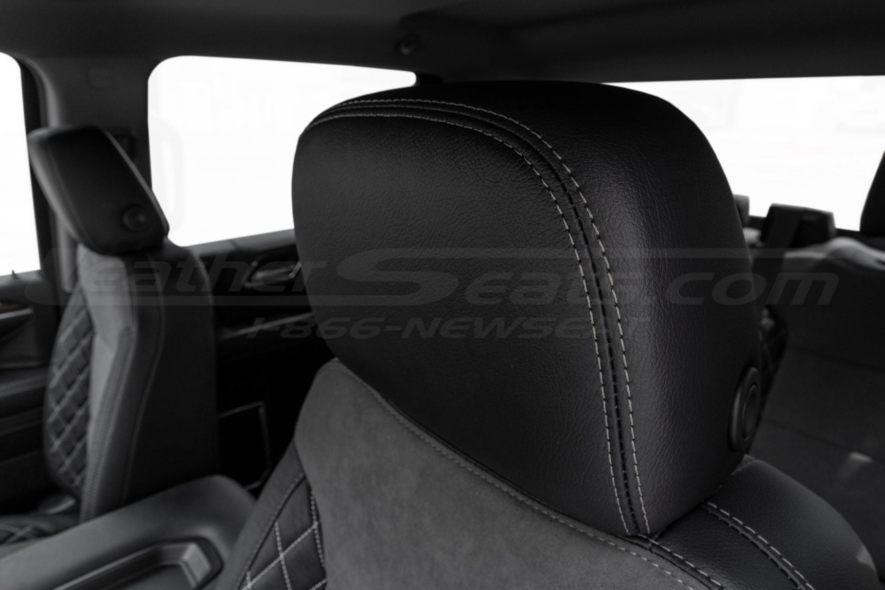 Black leather headrest with contrasting double-stitching close-up