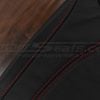 Red stitching on black leather
