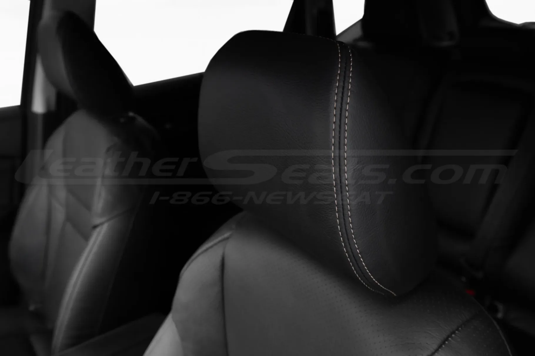 Black leather headrest with contrasting stitching close-up