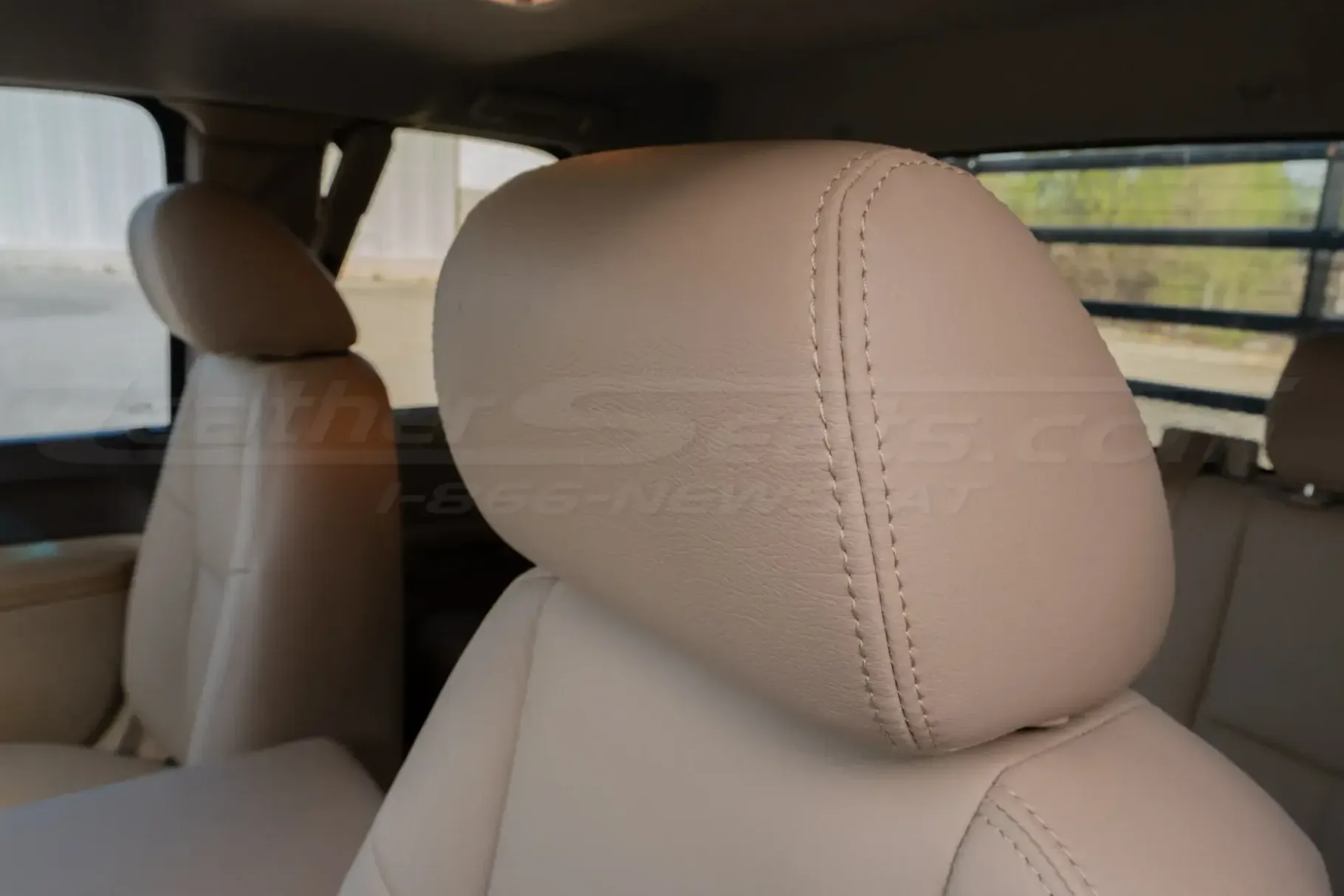 GMC Sierra leather headrest close-up with matching Sandstone stitching
