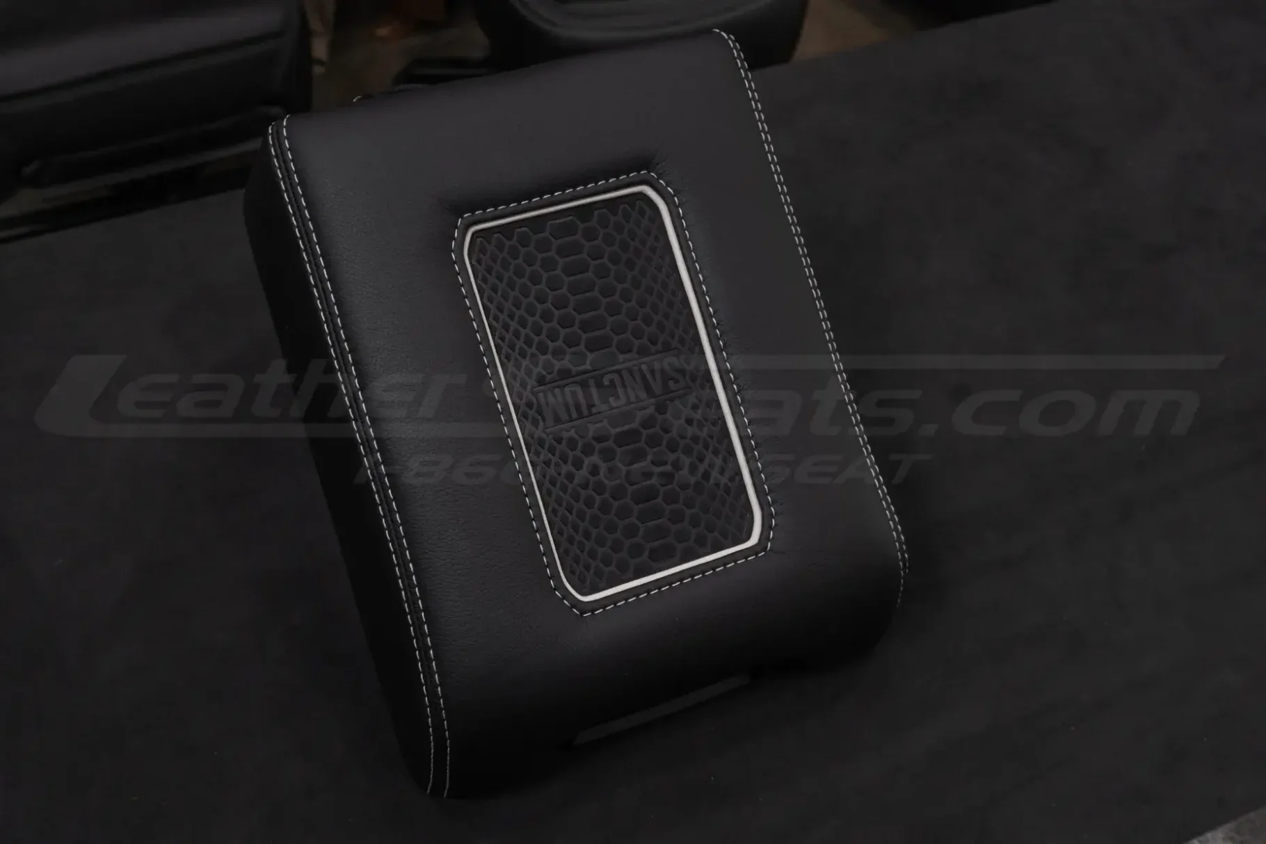 Black leather wireless charging console with white stitching and white trim ring